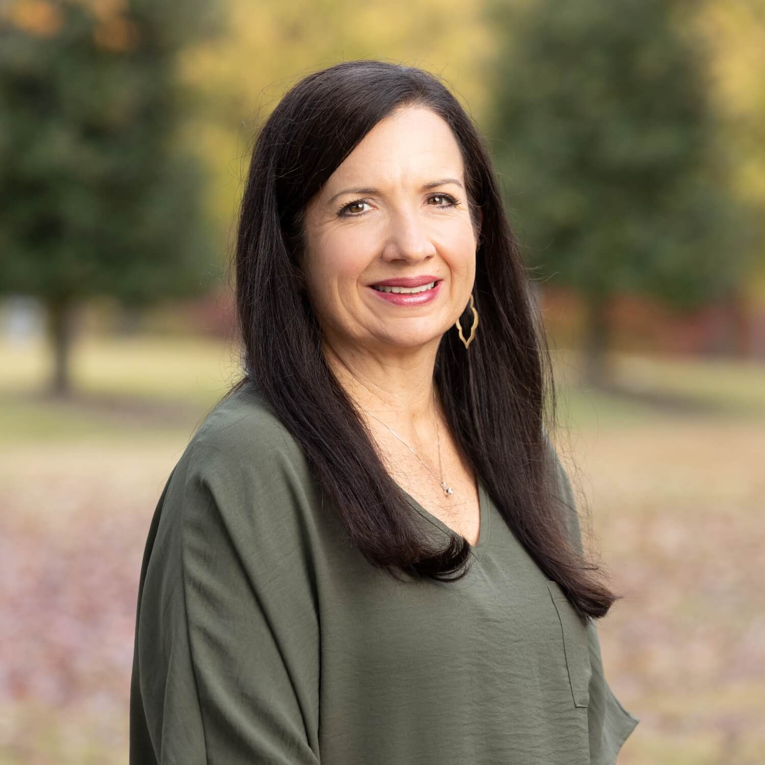 Jamie Ward, President of the Arkansas Association for Infant Mental Health, smiling professionally in an open park setting.