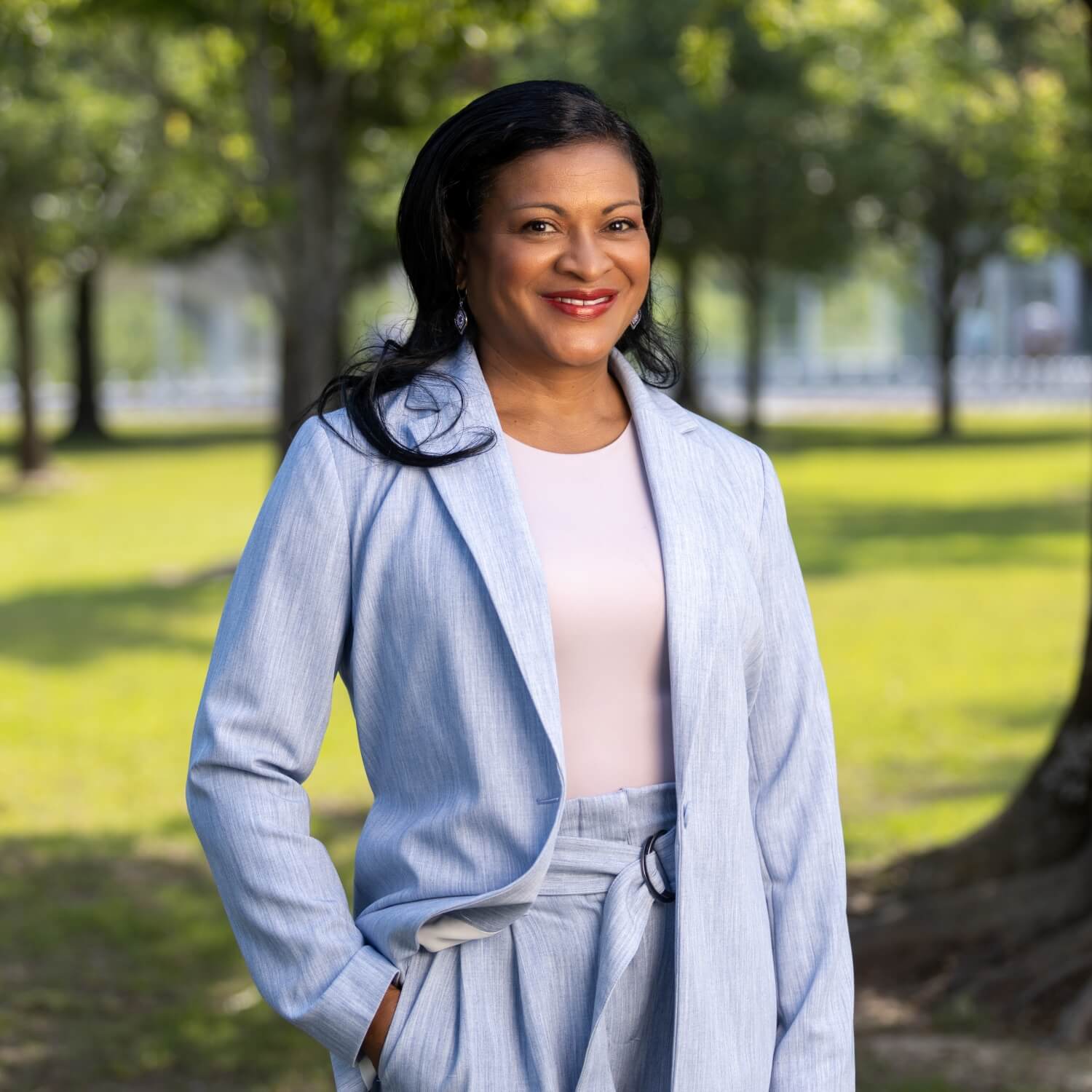 Sanci Richardson, Communities Manager at Excel by Eight, posing in a natural outdoor setting.