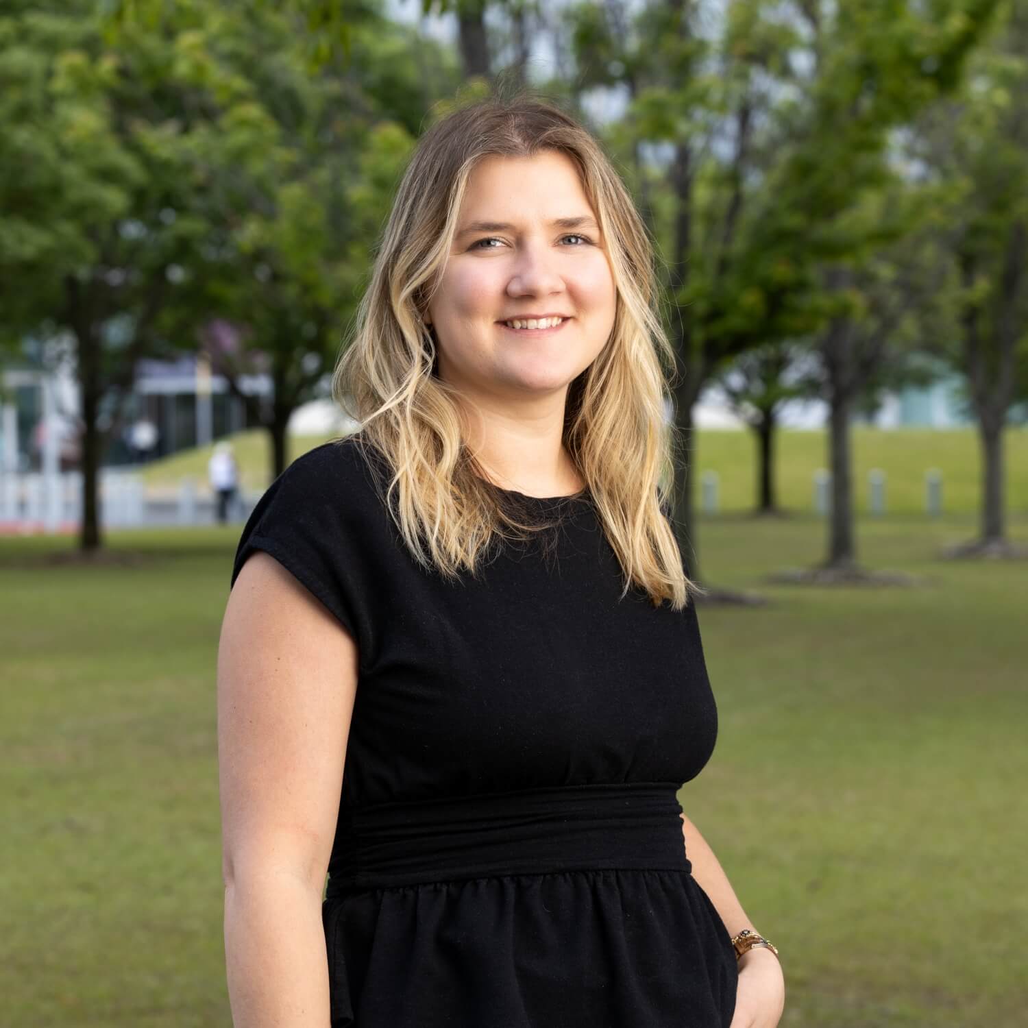 Tori Scott, Communities Manager for Excel by Eight, standing confidently in a sunny park.