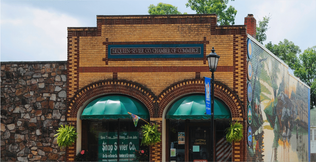Front view of the DeQueen–Sevier County Chamber of Commerce in Arkansas, with a distinctive brick façade and green awning.