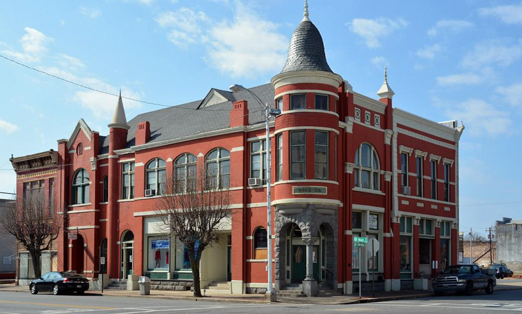 Vibrant red-brick Merchants & Planters Bank building in Jefferson County, Arkansas, featuring elegant arched windows and a unique turret.